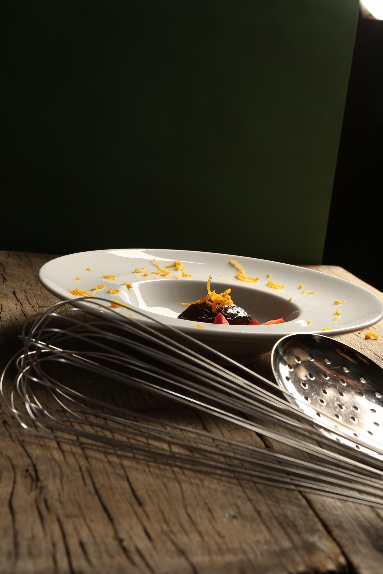 large editorial shot of plated tasting menu on dark table